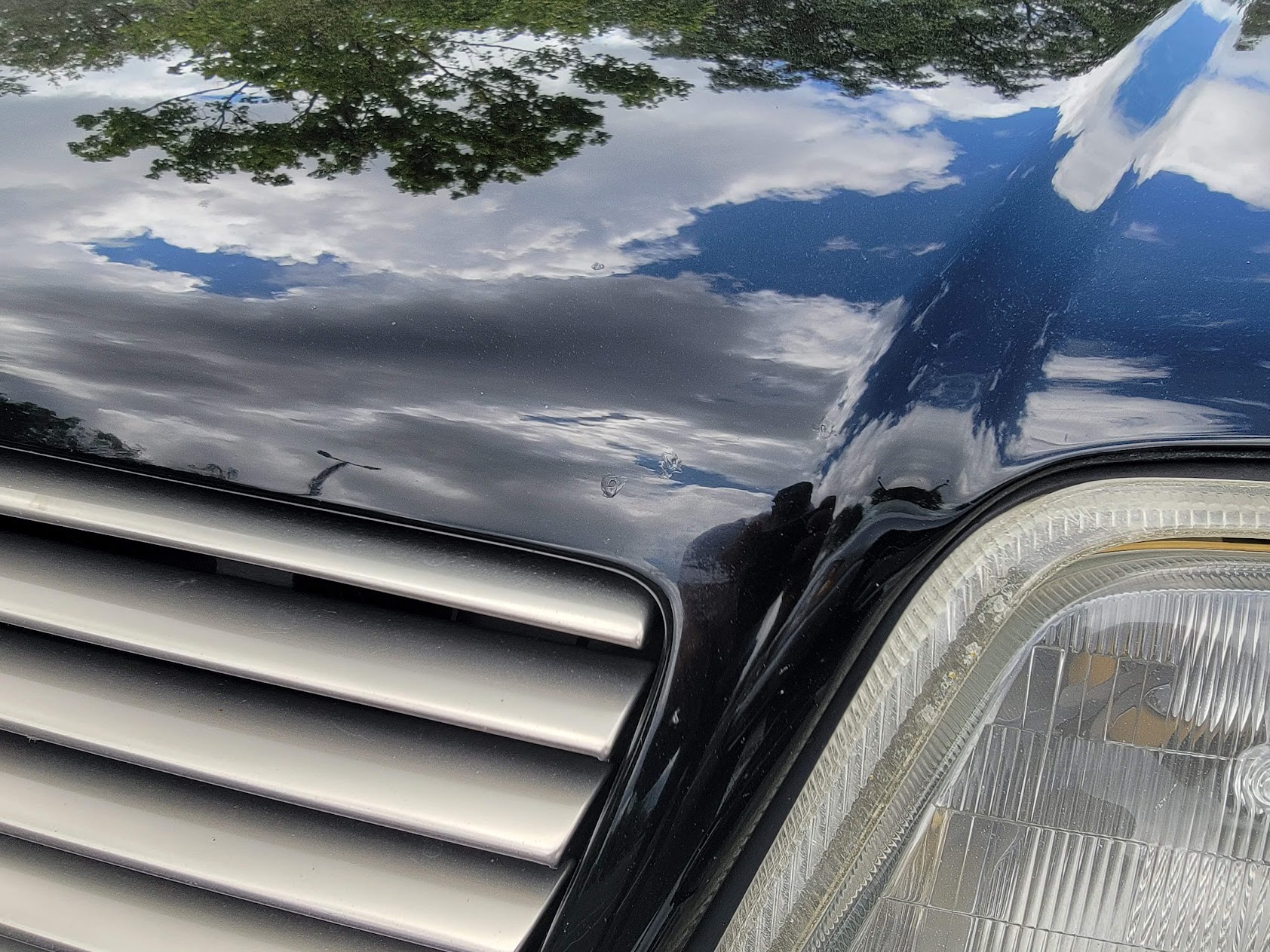 Close-up of paint chips on a black hood